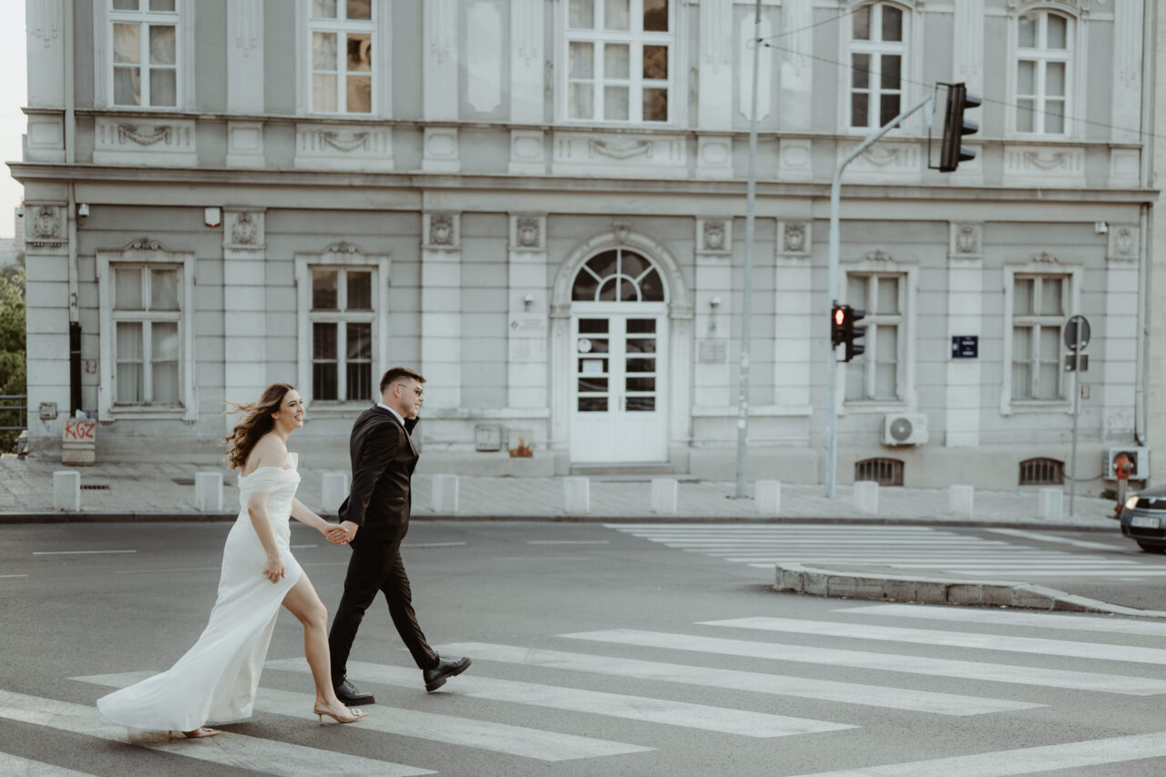 Mladenci prelaze ulicu u Beogradu tokom post-wedding fotografisanja